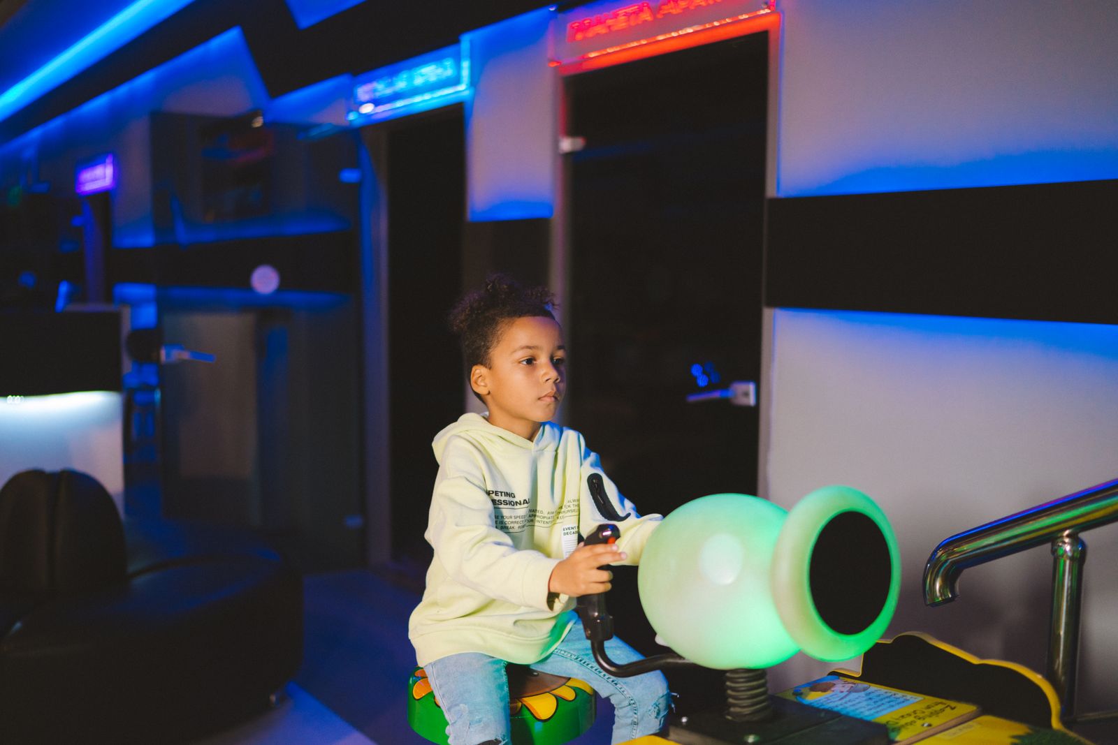 A child playing a colorful arcade game indoors