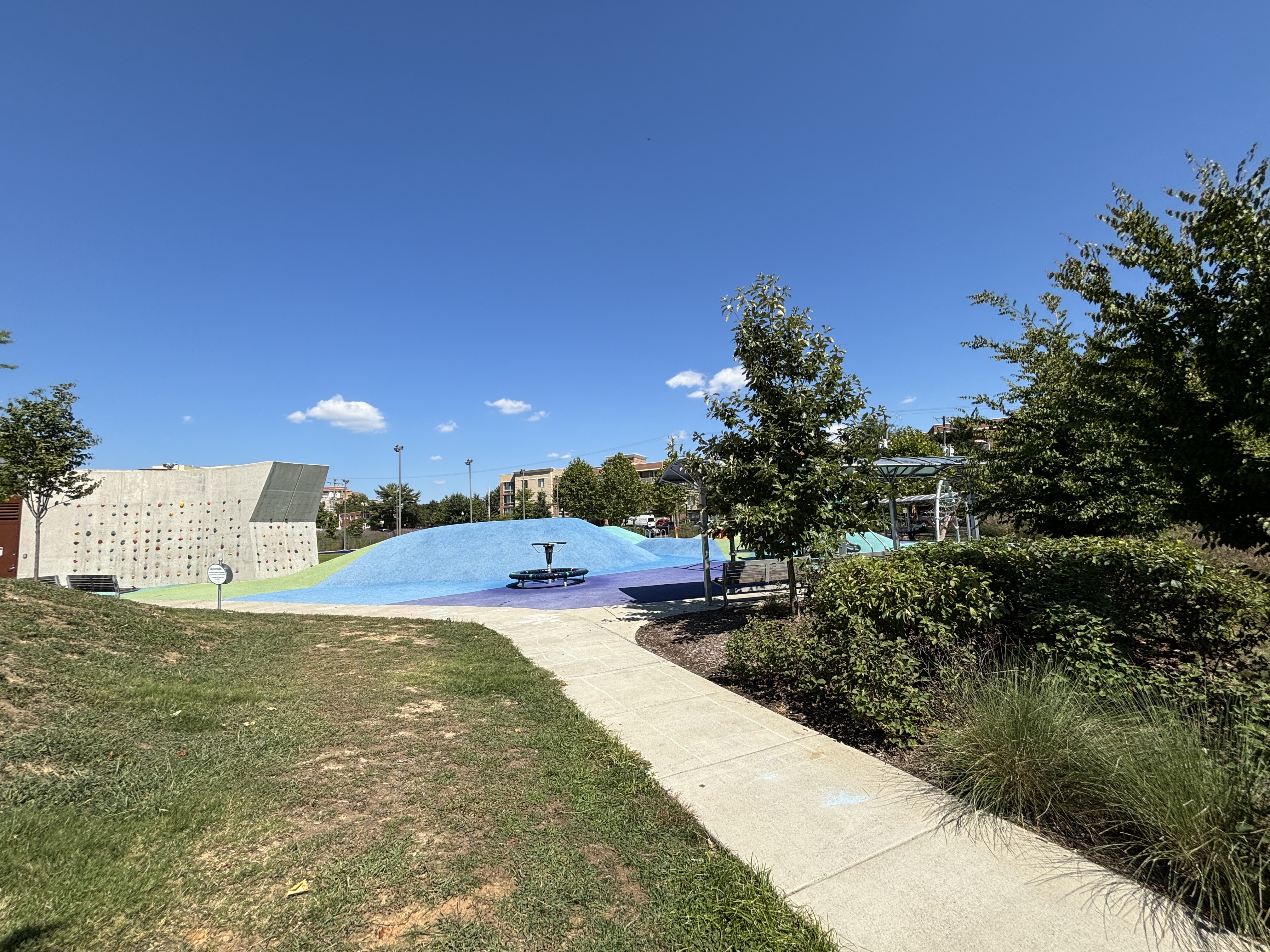 Mosaic Park’s climbing wall and blue play mound in Ballston, photographed in September 2024