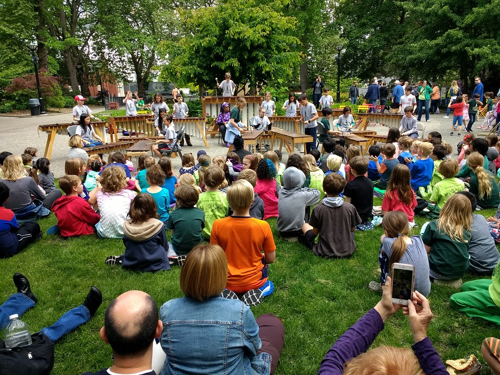 Families and children enjoying an outdoor community concert on the grass