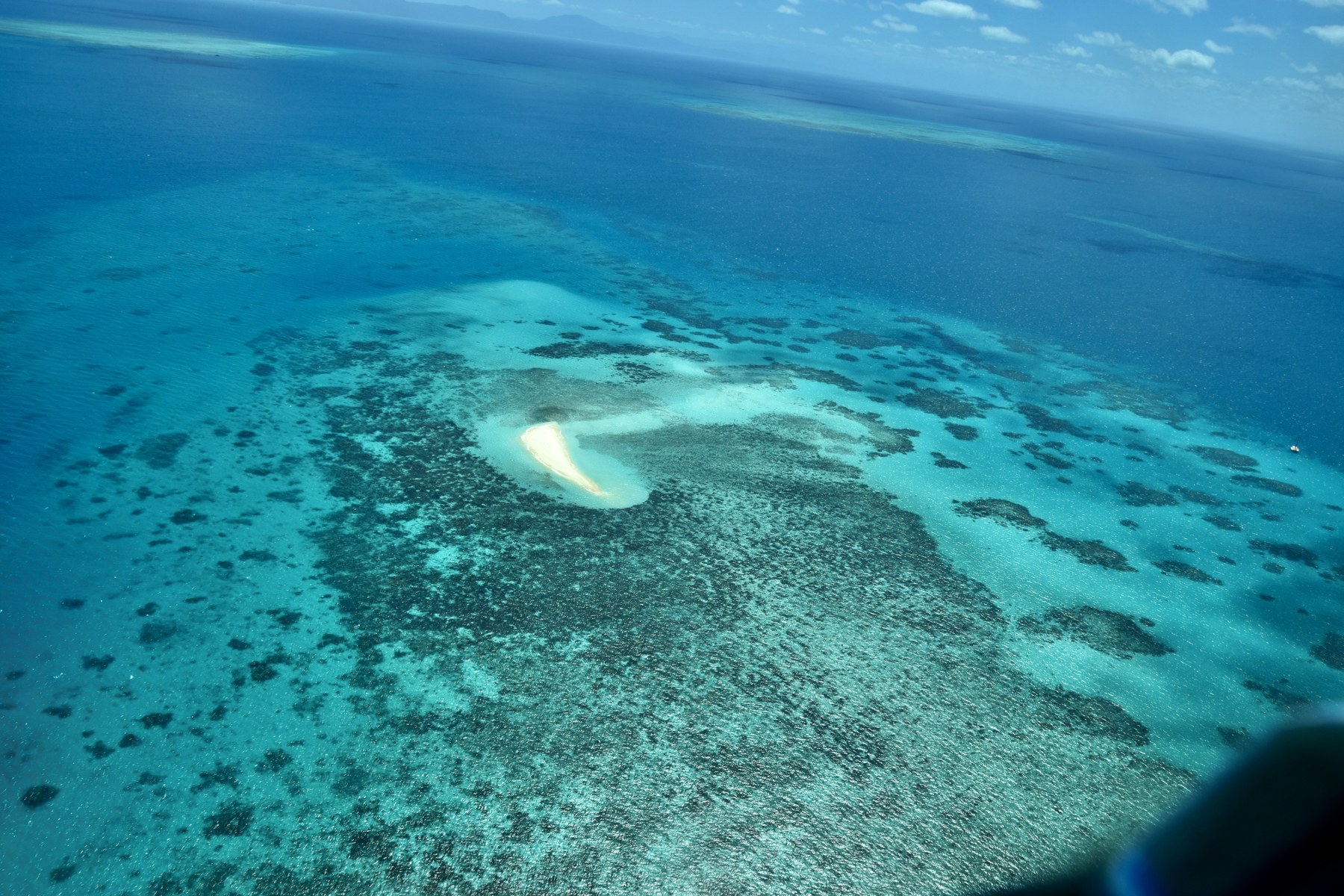 A turquoise reef and sandy cay seen from above on the Great Barrier Reef, Australia