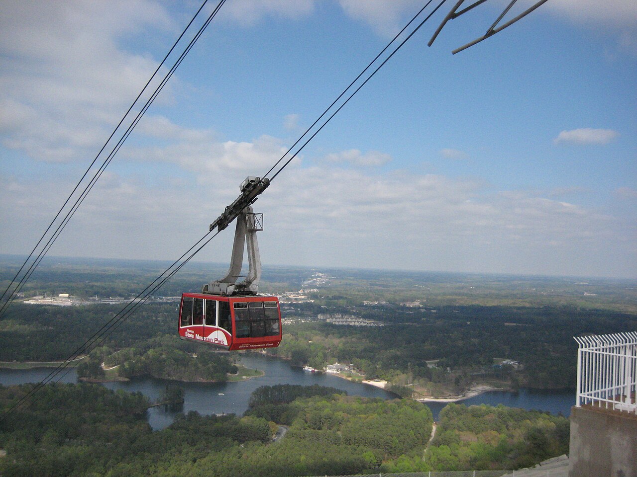 Red Summit Skyride cable car above the lake and trees at Stone Mountain Park